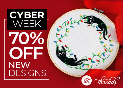 70% off new Christmas machine embroidery designs for Cyber Week. Image Features: Two cats tangled in Christmas lights in the shape of a wreath. The design is hooped in a hand embroidery hoop on a red background with ribbon.